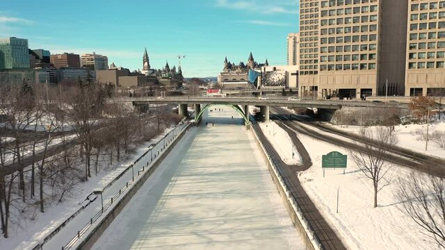 Aerial view of Ottawa's downtown skyline and the Rideau Canal with people ice skating on it