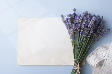 Lavender flowers in a bouquet with blank sheet old paper for text and lihgt from window on the table