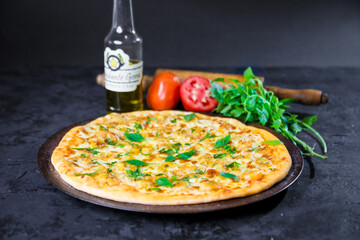 Pizza deliciosa com ingredientes na mesa de madeira com fundo escuro.