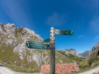 Sotres, Spain - September 3, 2020: Wooden signpost with directional signs on hiking trail in the River Duje valley near Sotres, Picos de Europa, Asturias.