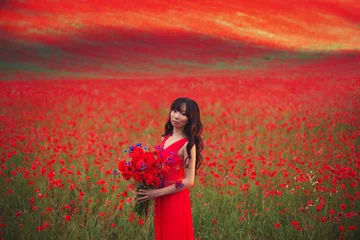Washable Wallpaper Murals Red Beautiful Asian girl with long hair in a red dress with a large bouquet of poppies and cornflowers in her hands on the background of a blooming field with wild red flowers.
