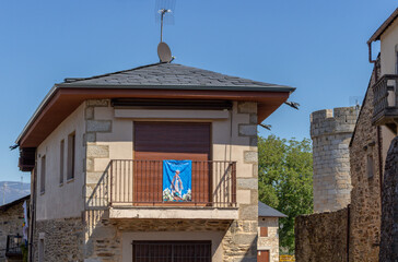 Puebla de Sanabria, Spain - September 6, 2020: Cobblestone street with picturesque stone residential buildings and flowered balconies in Puebla de Sanabría, Zamora province, Castilla y León.