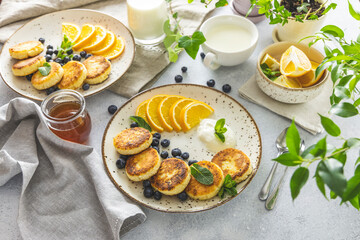 Delicious breakfast with curd fritter,  ricotta fritter or cottage cheese pancakes on ceramic plate. Gourmet healthy delicious morning breakfast. Morning sunny time