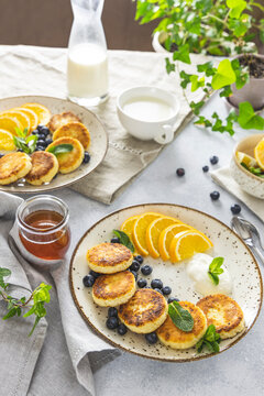 Delicious breakfast with curd fritter,  ricotta fritter or cottage cheese pancakes on ceramic plate. Gourmet healthy delicious morning breakfast. Morning sunny time