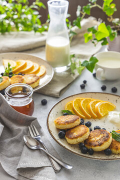Delicious breakfast with curd fritter,  ricotta fritter or cottage cheese pancakes on ceramic plate. Gourmet healthy delicious morning breakfast. Morning sunny time