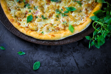 Pizza deliciosa com ingredientes na mesa de madeira com fundo escuro.