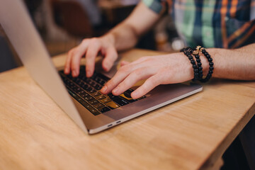 Man freelancer working using laptop, hands closeup