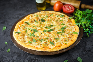 Pizza deliciosa com ingredientes na mesa de madeira com fundo escuro.
