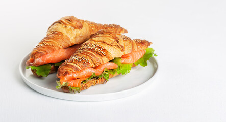 Croissant Sandwich with salmon and salad leaves