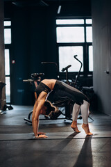 Fototapeta na wymiar Slim athletic woman doing exercise bridge at gym