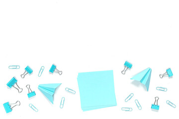 School and blue and white office supplies on white office table. Flat lay. Blue paper airplane and paper. Back to school concept.