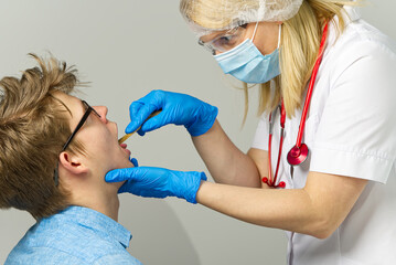 doctor examining child with sore throat at surgery