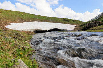 Thaw stream under glacier in the mountains