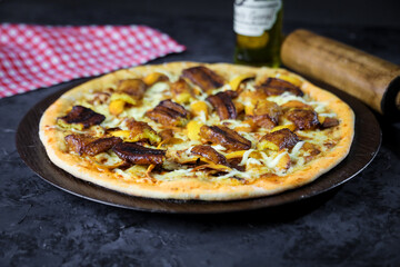Pizza deliciosa com ingredientes na mesa de madeira com fundo escuro.