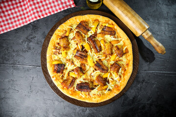 Pizza deliciosa com ingredientes na mesa de madeira com fundo escuro.