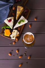 Beer and cheese. Glass of beer with cheese and walnuts. Ale and food concept. View from above, top view