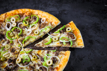 Pizza deliciosa com ingredientes na mesa de madeira com fundo escuro.