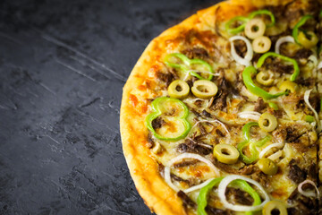 Pizza deliciosa com ingredientes na mesa de madeira com fundo escuro.