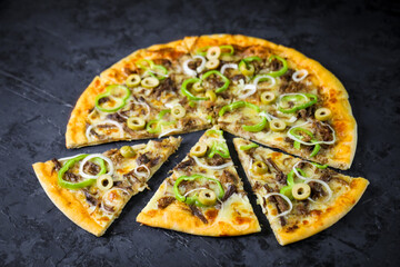Pizza deliciosa com ingredientes na mesa de madeira com fundo escuro.