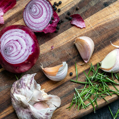 Food Preparation Garlic Red Onions Peppercorns and Rosemary on chopping Board