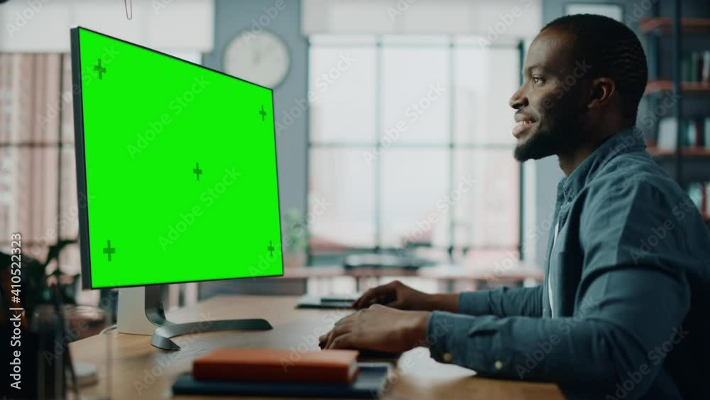 Poster handsome black african american specialist working on desktop computer with green screen mock up dis