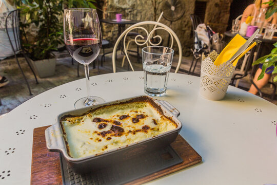 Traditional croatian food Zapeceni strukli with a glass of wine