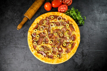Pizza deliciosa com ingredientes na mesa de madeira com fundo escuro.