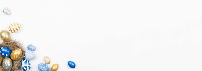 Easter golden blue decorated eggs in nest isolated on white background for web banner. Minimal easter concept. Happy Easter card with copy space for text. Top view, flatlay.