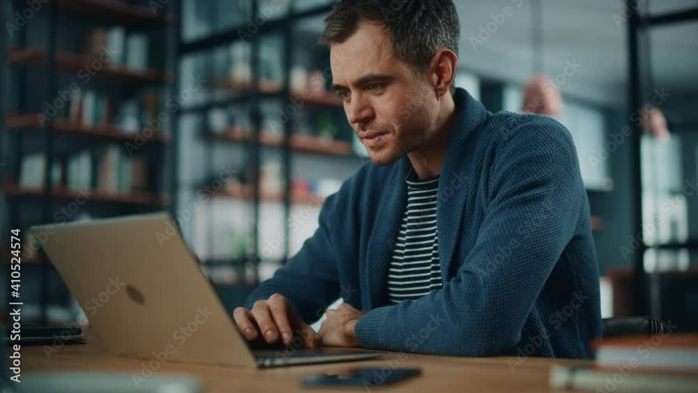 Leinwandbilder handsome caucasian man working on laptop computer while sitting behind desk in cozy living room. fre