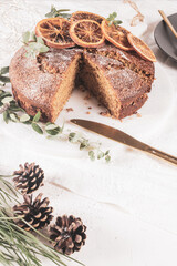 Christmas orange and spice cake. Decorated with dried oranges on kitchen countertop