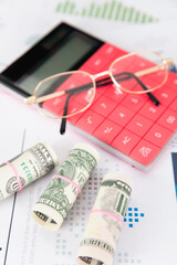 Fototapeta premium Calculator, dollar bill and a pair of glasses on financial materials
