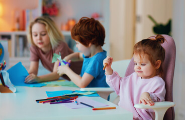 cheerful kids, siblings having fun, drawing with color pencils and cutting with scissors, home activities
