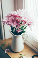 Pastel pink flowers on a vintage window sill.