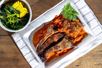 Sambal santan ikan panggang or ikan pari asap is smoke Stingray fish preserved by fumigation sauce, served with spicy coconut milk sauce and spinach soup.