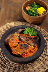 Sambal santan ikan panggang or ikan pari asap is smoke Stingray fish preserved by fumigation sauce, served with spicy coconut milk sauce and spinach soup.