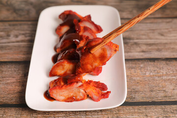 Roasted pork thai local food with red sauce on wood background