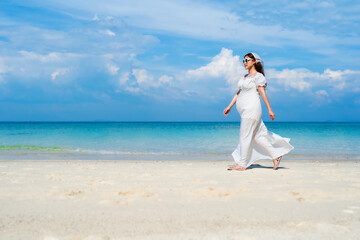 Fototapeta na wymiar pregnant woman walking on the sea beach at Koh MunNork Island, Rayong, Thailand
