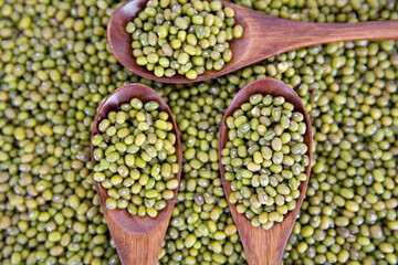 Mung beans and three wooden spoons