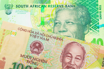 A macro image of a shiny, green 10 rand bill from South Africa paired up with a colorful, plastic ten thousand dong note from Vietnam.  Shot close up in macro.