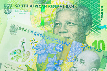 A macro image of a shiny, green 10 rand bill from South Africa paired up with a green, plastic one leu bank note from Romania.  Shot close up in macro.