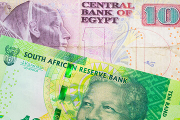 A macro image of a shiny, green 10 rand bill from South Africa paired up with a pink and purple ten pound bank note from Egypt.  Shot close up in macro.