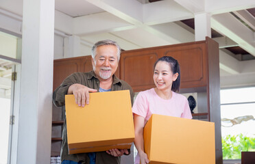 Young daughter and senior father carrying boxes into new home, Happiness family on moving day concepts