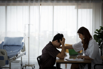 Young Asian female doctor is smiling and touching patient's sholder in hospital room. Medical healtcare concept.