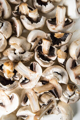 Raw sliced mushrroms on a cutting board.