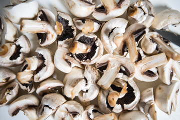 Raw sliced mushrroms on a cutting board.