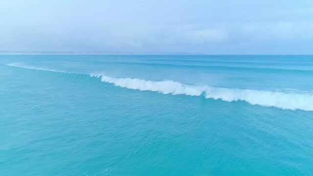 A wave breaking the silence of the sea under the blue sky on the west coast of Bridgewater Bay.