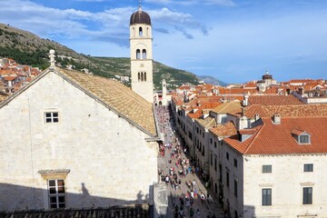 Fototapeta premium A great view of the old town in Dubronvik Croatia from the perspective of the walls of Dubronvik. The view looks down on Stradun Street full of tourists walking around on a busy summer day 