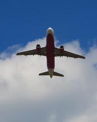 青空と雲をバックに離陸する飛行機