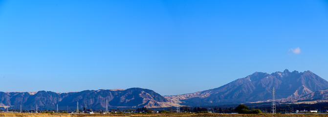 雪景色　美しい晴天空を背景に阿蘇山風景 (阿蘇五岳：根子岳・高岳・中岳・烏帽子岳・杵島岳) 2021年冬　日本・熊本県阿蘇市 パノラマ撮影 Panoram Snow scene Mt. Aso scenery against the backdrop of a beautiful clear sky Winter 2021, Aso City, Kumamoto Prefecture, Japan