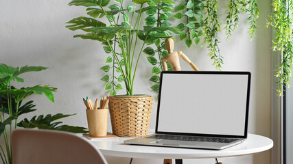 Laptop include clipping path on coffee table in Biophilia leisure corner